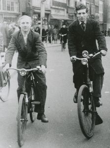 876094 Portret van Kees Korvezee en rechts Ries Veenendaal, beiden wonend in de Oranjestraat in Wijk C, op de fiets op ...